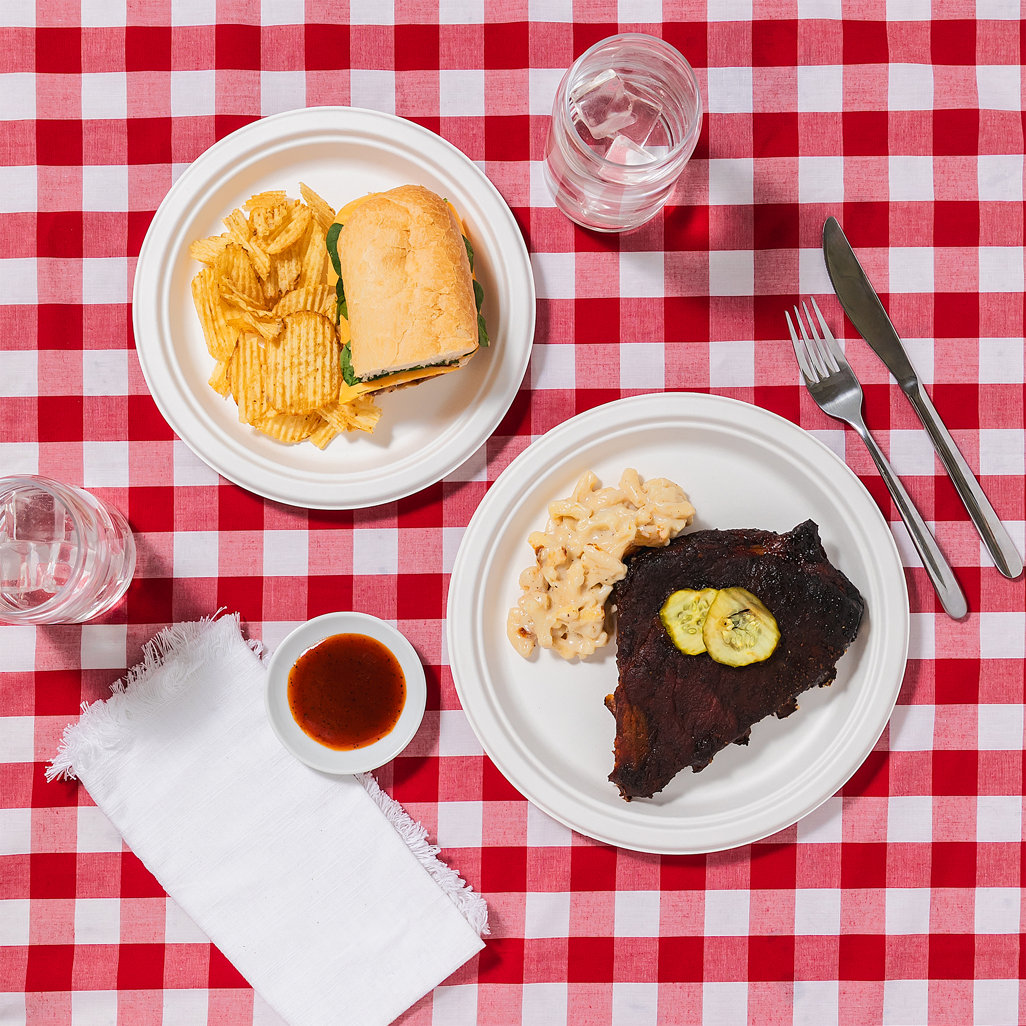 Combined lifestyle - Lunch and dinner plates with BBQ and sandwich on gingham